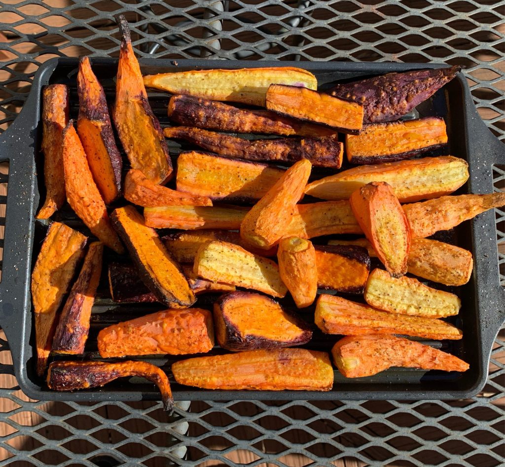 Roasted carrots on a roasting pan on a metal outdoor table