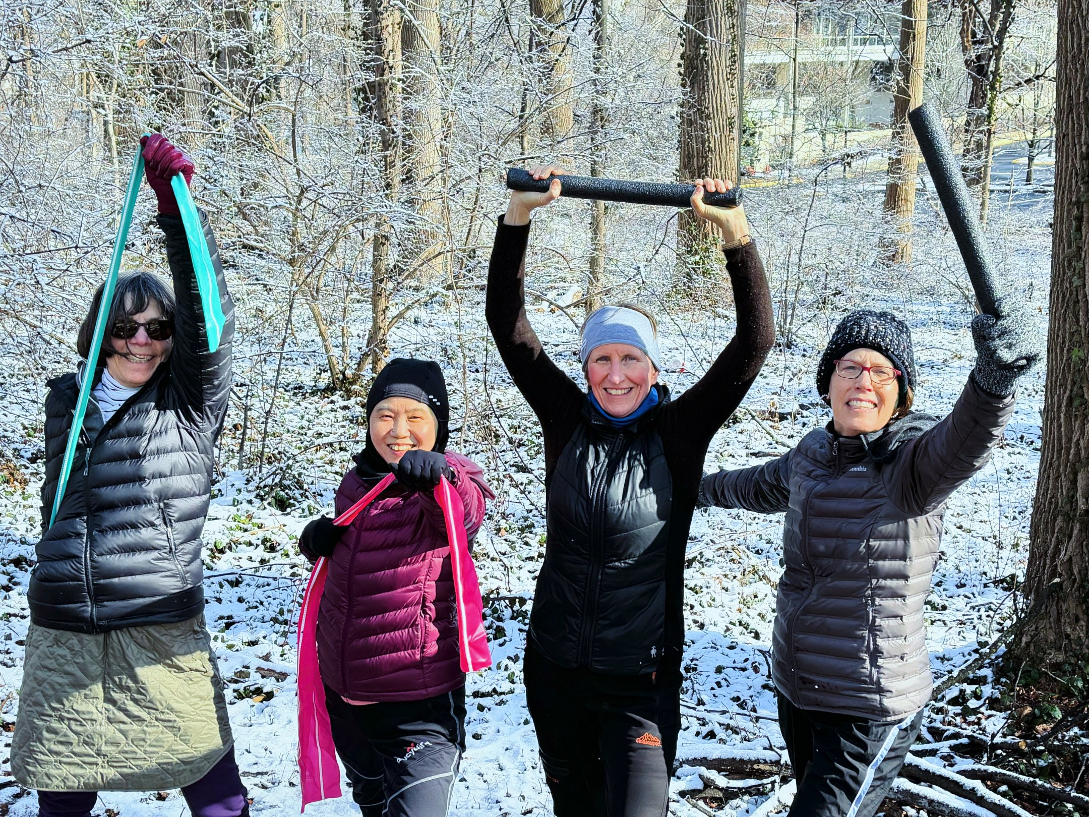Four women exercising in a snowy forest