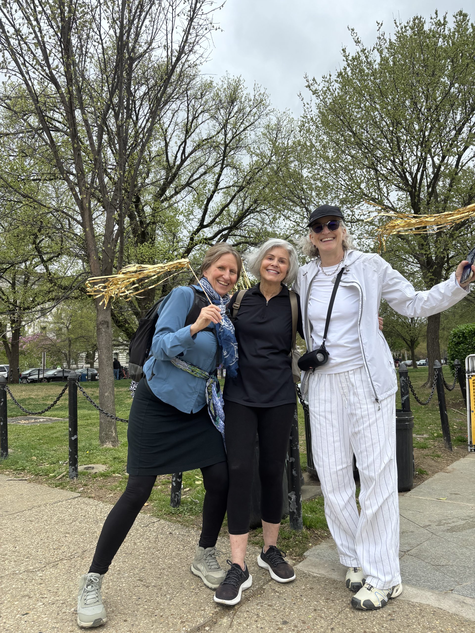 Three happy women holding streamers